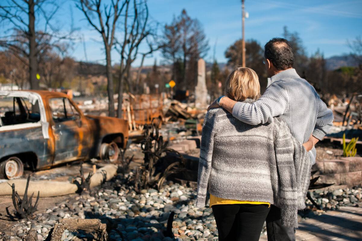 Couple checking ruins after fire disaster. Couple checking ruins after fire disaster.