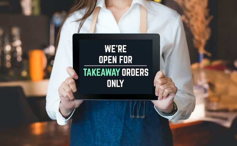 Waitress Holding Takeout Only Sign